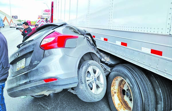 Termina vehículo debajo de tráiler