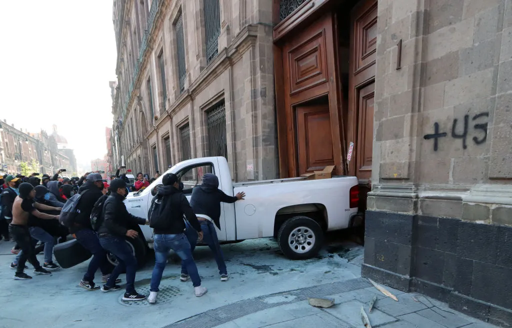 MANIFESTANTES DERRIBAN PUERTA DE PALACIO NACIONAL DE MÉXICO DURANTE MAÑANERA DE AMLO EN PROTESTA POR CASO AYOTZINAPA
